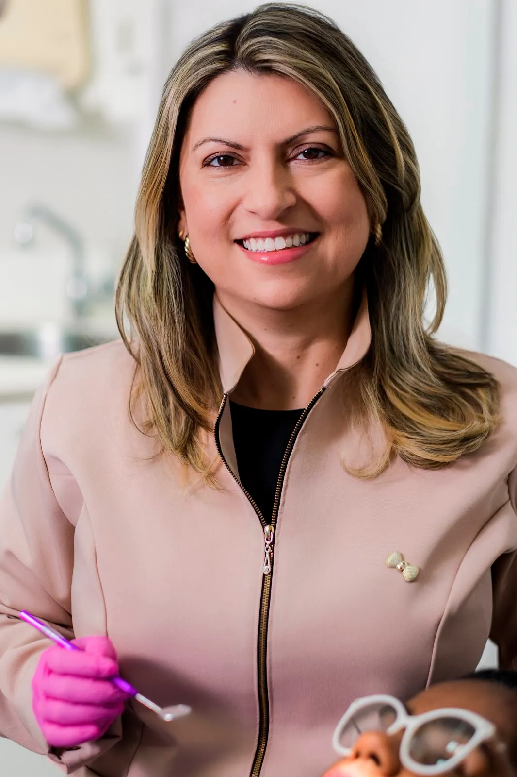 Dra. Sulamita Manhães, especialista em Periodontia, de uniforme, em atendimento